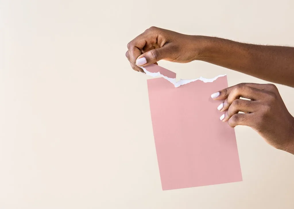 A piece of paper being torn as a metaphor for a frenulum tear.
