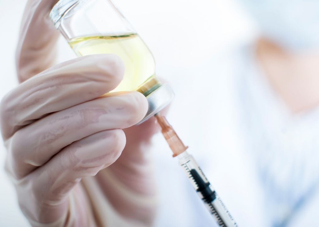 A men's health clinic professional administering P Shot treatment to a patient.