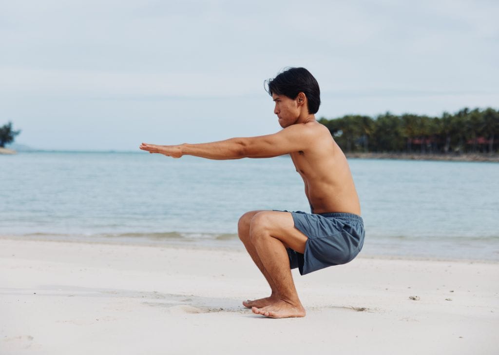 A man learning how to do kegel exercises by doing squats.