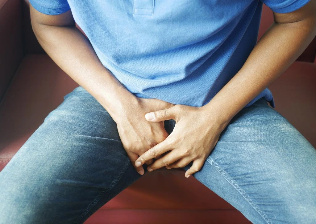 A man experiencing groin pain from a curved erection caused by Peyronie's Disease.