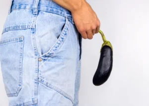A man using an eggplant as a metaphor for painful erections caused by frenulum breve.