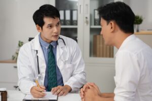 A doctor engages in a calm consultation with a patient in a discreet, professional setting.