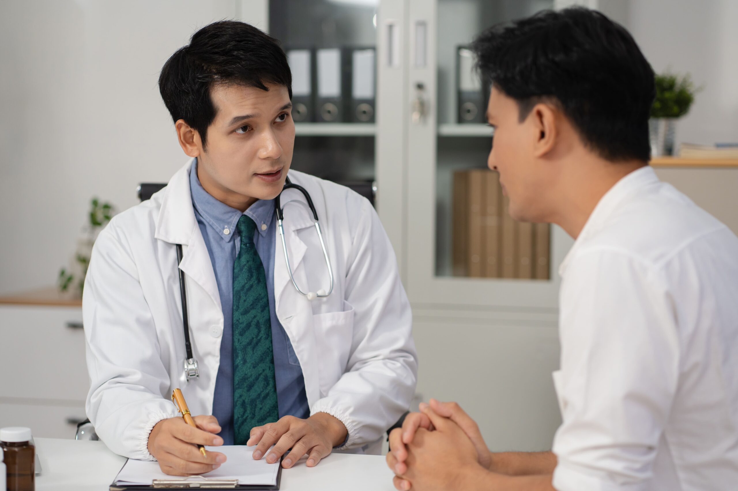 A doctor engages in a calm consultation with a patient in a discreet, professional setting.